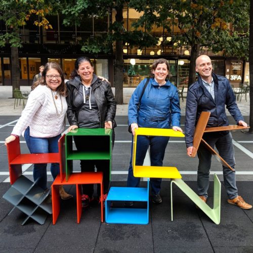 Glenda Sims, Estelle Weyl, Janet Swisher and Adrian Roselli pose with metal letter-shaped chairs spelling "HACK" and "MdN"